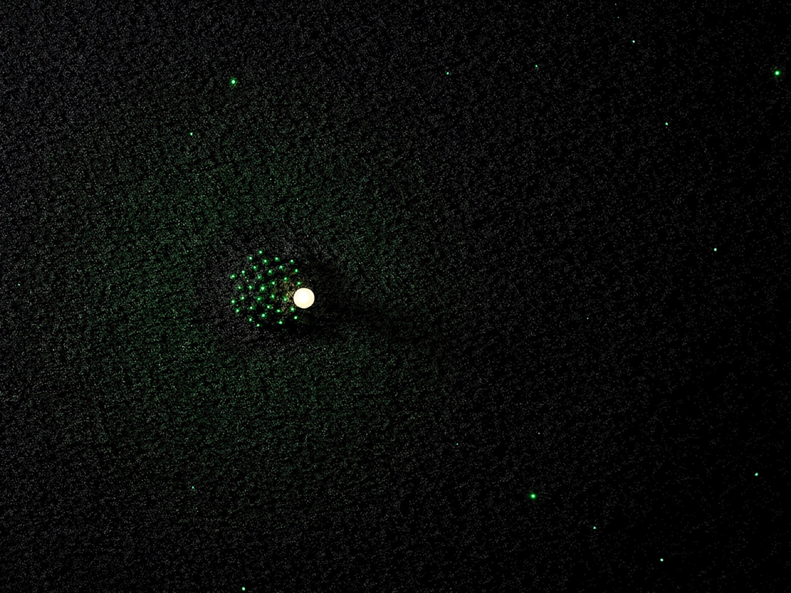 Fylle brand artwork: a small bright white core surrounded by a dense cluster of neon-green nodes, fading into sparse scattered points across a grainy black field.